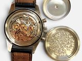 a close up of a watch with a leather strap