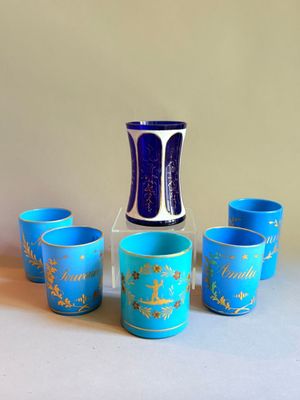 cinq tasses et un vase posés sur une table