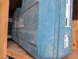 une valise bleue posée sur une étagère dans une pièce
