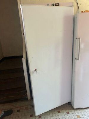 two white refrigerators sitting in a kitchen next to each other