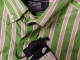 a close up of a green and pink striped shirt with a tag on it