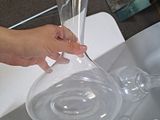 a person that is cutting a glass vase on a table