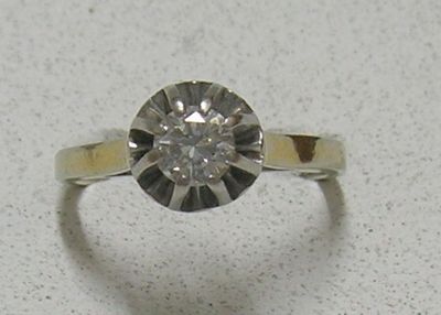 une photo d'une bague en diamant posée sur une table, sur fond blanc