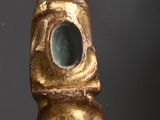 a gold statue of a hand reaching out of a tower