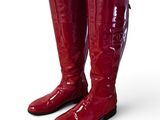 pair of red boots on a white surface with a white background
