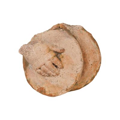 un petit morceau de poterie sur lequel est représenté un visage