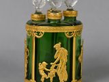 a green glass jar with a gold decoration on it
