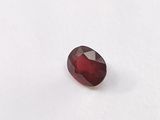 a red garnet stone sitting on top of a white surface