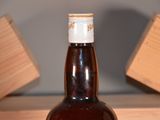 a bottle of beer sitting on a table with a wooden block in the background