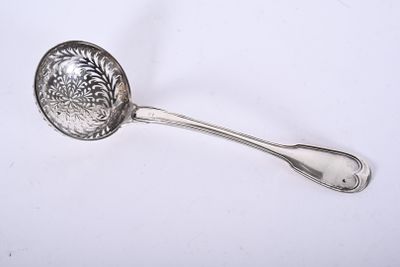 une cuillère en argent ornée d'un arbre, posée sur un fond blanc