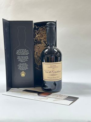 la bouteille de vin se trouve à côté d'une boîte sur laquelle est collée une étiquette