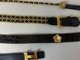 trois ceintures avec des chaînes en or et une ceinture noire avec une boucle en or