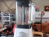 un mixeur posé sur une table en verre dans une pièce