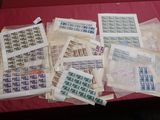a lot of stamps on a table with a red table cloth
