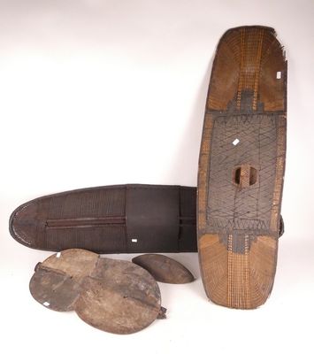 une planche de surf et une paire de chaussures posées sur une surface blanche