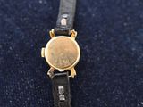 a close up of a wrist watch on a blue cloth