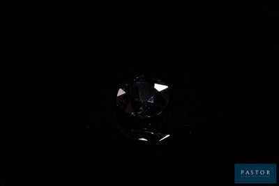 a close up of a diamond in the dark with a black background