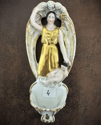 une statue représentant un ange tenant un chien dans un bol
