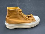 a close up of a pair of yellow sneakers on a gray surface