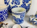 many blue and white vases and plates on the table