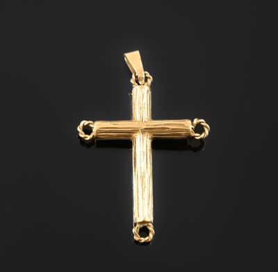 a gold cross pendant on a black background