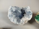 a small piece of crystal on the table next to some rocks