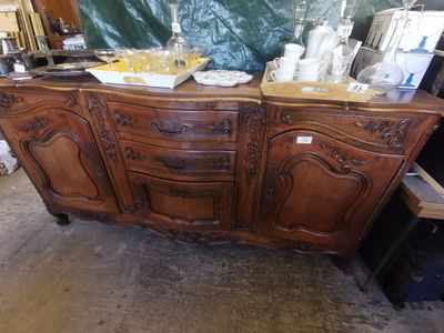 a large wooden cabinet that has a lot of items on it