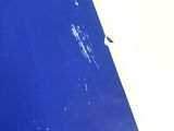 a close up of a piece of blue paint on a wall