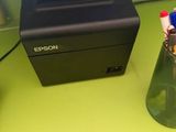 a picture of a printer sitting on a desk next to a glass of water