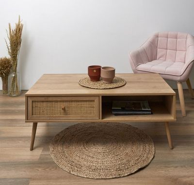 une table basse avec un tiroir et une chaise à l'arrière-plan