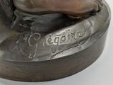 bronze statue of a woman with her foot resting on a rock