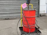 a red barrel sitting on a cart with a sign on it