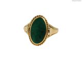 gros plan d'une bague en or avec une pierre verte