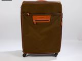 La valise marron et orange est posée sur une surface blanche.