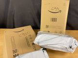 two bags of white paper sitting on top of a table next to a cardboard box