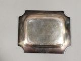 a silver tray on a white wall with a silver handle