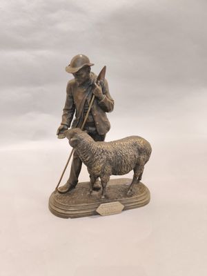 une statue représentant un homme avec un chien et un mouton