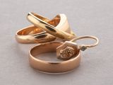 two gold rings with a diamond in them on a table