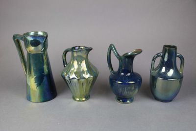 four different colored vases sitting next to each other on a table