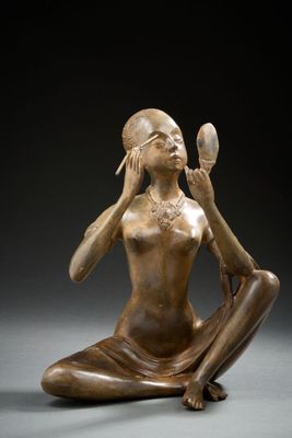 an image of a bronze statue of a woman sitting on the ground