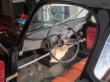 a black car with a red seat and a steering wheel