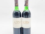 deux bouteilles de vin posées l'une à côté de l'autre sur une surface blanche