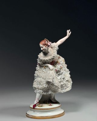 figurine en porcelaine représentant une femme vêtue d'une robe blanche et de chaussures rouges