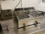 two deep fryers sitting on a counter in a kitchen