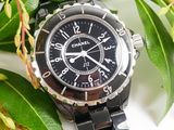 a close up of a black watch on a white surface