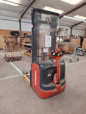 a forklift in a warehouse with a lot of wood