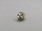 a close up of a silver bead on a gray surface
