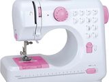 une machine à coudre blanche et rose posée sur une surface blanche