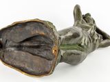 bronze statue of a woman laying on her back with her hands in her mouth