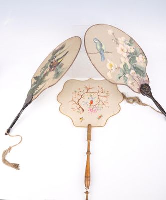deux éventails ornés de motifs, posés sur une table